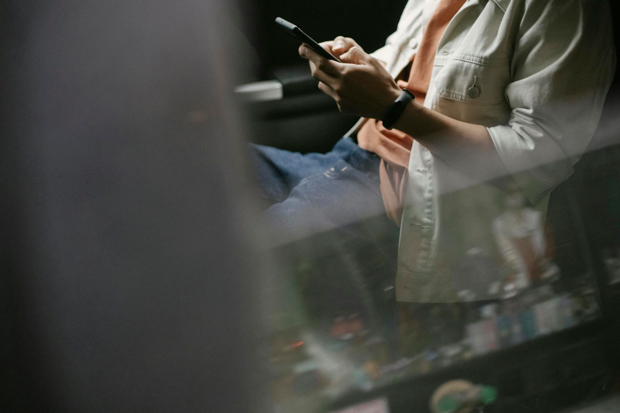 Casual man texting on smartphone while traveling as a passenger in a car.